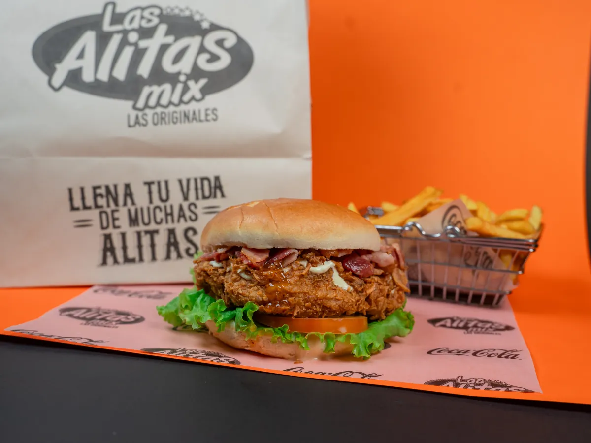 Chicken Mix: hamburguesa de pechuga de pollo apanada crispy con tocineta, salsas, lechuga y tomate en pan brioche